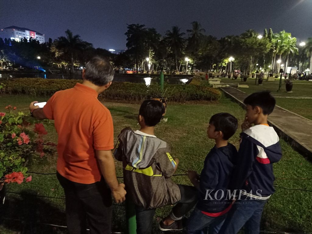 Warga dan keluarganya berekreasi di taman kota di Jakarta, beberapa waktu lalu.
