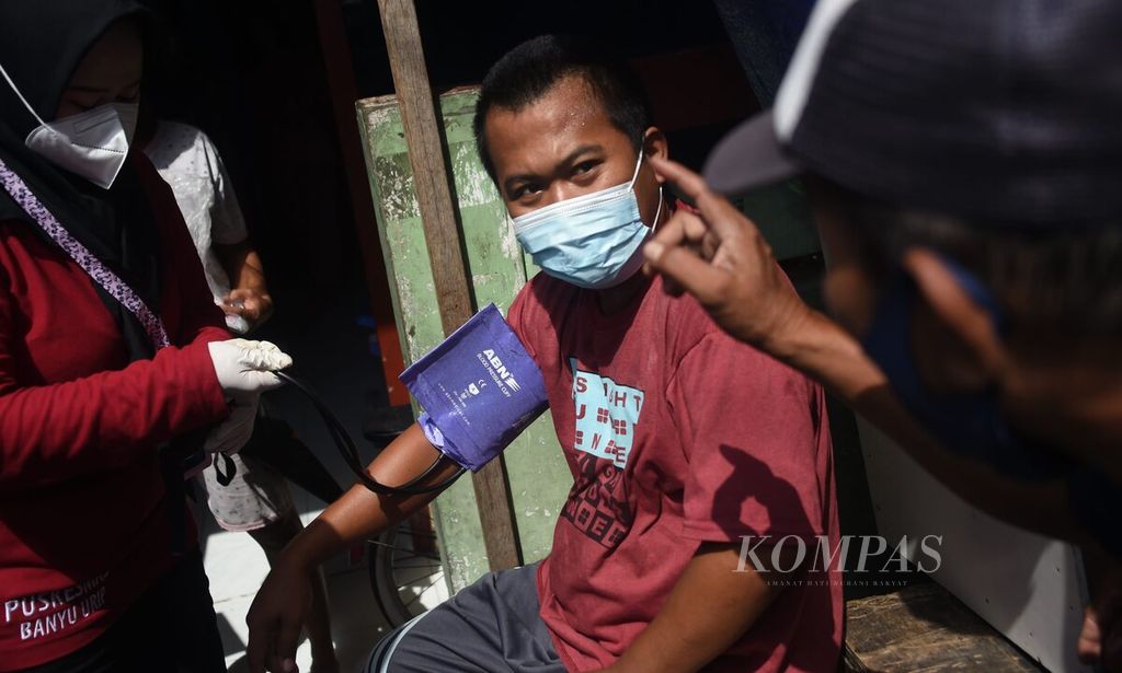 Tenaga medis Puskesmas Banyuurip memeriksa tekanan darah warga saat akan melakukan vaksinasi kepada orang dengan gangguan jiwa (ODGJ) dan penyandang disabilitas di RW 007 Kecamatan Sawahan, Kota Surabaya, Jawa Timur, Jumat (4/6/2021). 
