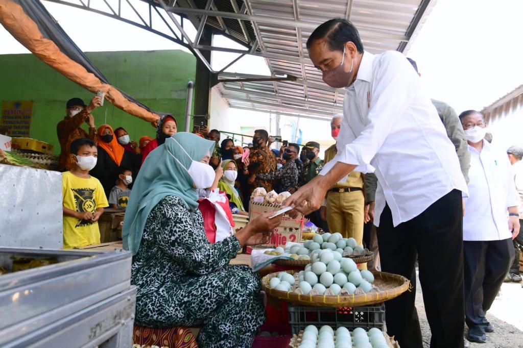 Presiden Joko Widodo membagikan bantuan langsung tunai (BLT) minyak goreng dan bantuan modal kerja (BMK) kepada para pedagang di Pasar Tanjung, Brebes, Rabu (13/4/2022). Dalam kunjungan kerjanya, Presiden juga mengecek harga kebutuhan masyarakat, seperti bahan pangan dan minyak goreng.