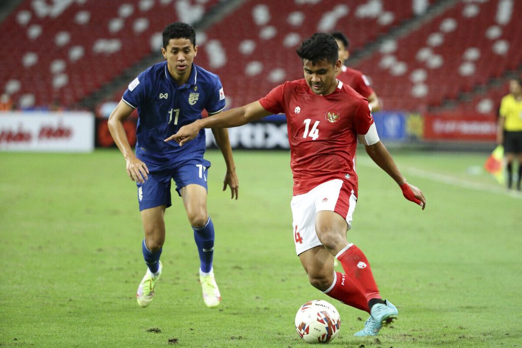 Bek Indonesia, Asnawi Mangkualam, menggiring bola saat laga pertama final Piala AFF 2020 antara Indonesia dan Thailand di Singapura, 29 Desember 2021. Timnas Indonesia saat itu menggunakan jersei produksi Mills.