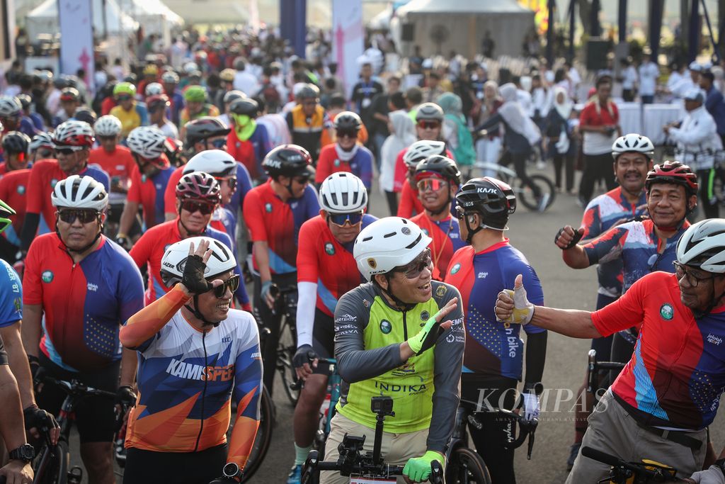 Penggagas Cycling Anywhere to Save the Earth, Royke Lumowa (jersei hijau), menyapa rekan pesepeda sebelum bersepeda menuju Paris, di kawasan Monumen Nasional, Jakarta, Sabtu (8/7/2023). 