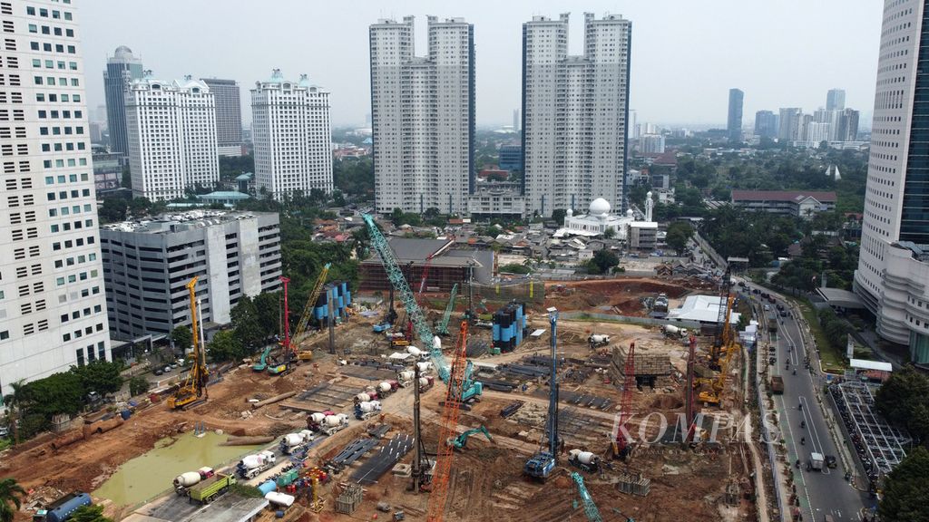 Alat berat digunakan pekerja untuk menyelesaikan pembangunan gedung pencakar langit Oasis Central Sudirman di Jalan Jenderal Sudirman, Jakarta, Kamis (8/6/2023). Gedung dua menara masing-masing setinggi 65 lantai (276 meter) dan 75 lantai (331 m) ini dibangun secara kerja sama antara PT Taspen dengan Mitsubishi Estate Co dan PT Benhil Property. Gedung dengan nilai investasi Rp 10,6 triliun ini diklaim akan menjadi gedung tertinggi di Indonesia. Nantinya gedung ini akan difungsikan sebagai pusat bisnis, residensial (apartemen), dan perkantoran. 