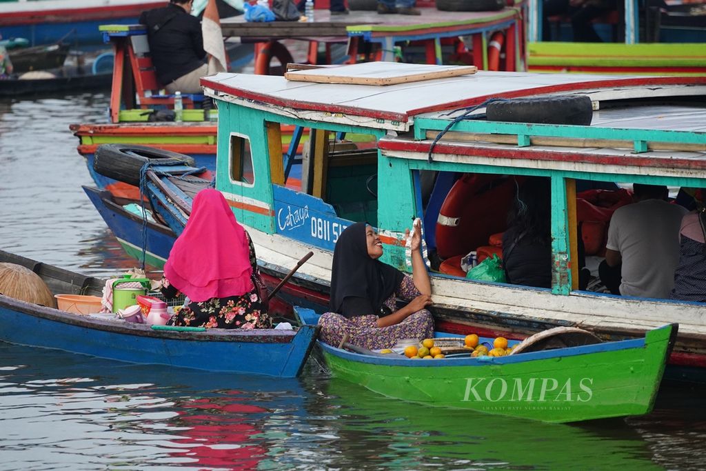 Pedagang menawarkan barang dagangannya kepada wisatawan yang datang di Pasar Terapung Lok Baintan, Banjarmasin, Kalimantan Selatan, Sabtu (24/8/2019). 