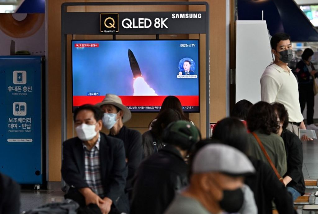 Warga menonton televisi di stasiun kereta api di Seoul, Korea Selatan, Minggu (25/9/2022), yang menyiarkan ulang berita hasil rekaman uji coba rudal Korea Utara, 