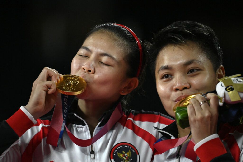 Pasangan ganda putri Indonesia, Apriyani Rahayu/Greysia Polii (kiri) berpose dengan medali emas yang berhasil mereka peroleh dalam final ganda putri bulu tangkis Olimpiade Tokyo 2020 pada 2 Agustus 2021.