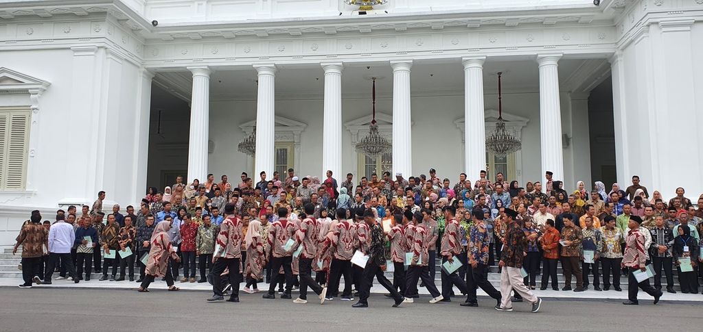 Warga yang menerima sertifikat dan hadir dalam penyerahan sertifikat tanah dan peluncuran sertifikat tanah elektronik secara daring dan luring berfoto bersama Presiden Joko Widodo di depan Istana Merdeka, Jakarta, Senin (4/12/2023).
