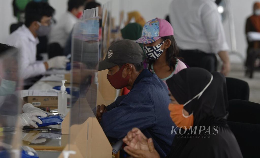 Para orangtua penerima Kartu Jakarta Pintar (KJP) bergiliran mengurus buku rekening dan kartu ATM Bank DKI melalui layanan khusus Bank DKI untuk peserta program KJP di kawasan Matraman, Jakarta Timur, Senin (23/11/2020).