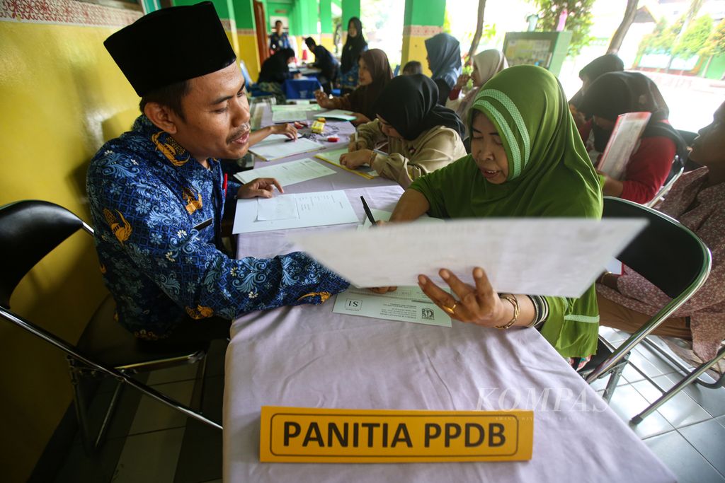 Guru memberi penjelasan kepada orangtua calon siswa di posko pelayanan informasi pendaftaran penerimaan peserta didik baru DKI Jakarta tahun 2024 di SD Negeri Grogol Selatan 08, Kebayoran Lama, Jakarta Selatan, Senin (20/5/2024). Layanan tersebut untuk membantu orangtua yang mengalami kesulitan mendaftar secara daring.