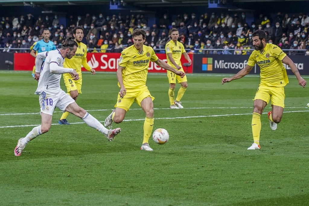 Pemain Real Madrid, Gareth Bale (kiri), menendang bola ke arah gawang Villarreal pada laga Liga Spanyol di Stadion La Ceramica, Villarreal, Sabtu (12/2/2022) dini hari WIB. Laga itu berakhir imbang 0-0. 