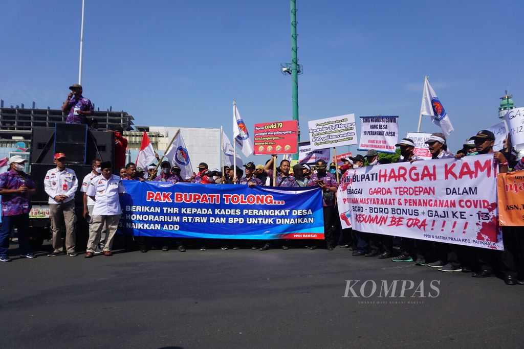 Para kepala desa dan perangkat desa se-Kabupaten Banyumas menggelar aksi damai menuntut tunjangan hari raya serta kesejahteraan di Alun-alun Purwokerto, Banyumas, Jawa Tengah, Senin (11/7/2022).