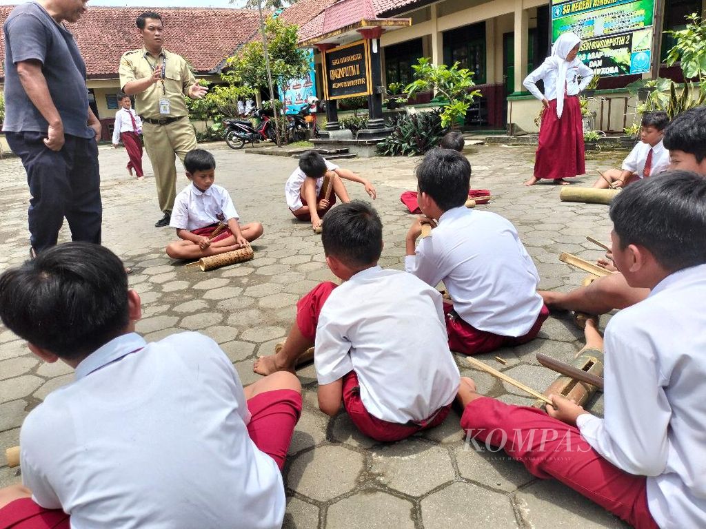 Di bawah panduan guru, siswa-siswa SD Ringinputih II, Kecamatan Borobudur, berlatih memainkan lagu menggunakan kentongan, Senin (7/11/2022). Musik yang dimainkan adalah bagian dari upaya memberikan <i>cheering </i>bagi para pelari Borobudur Marathon 2022, Minggu (13/11/2022).