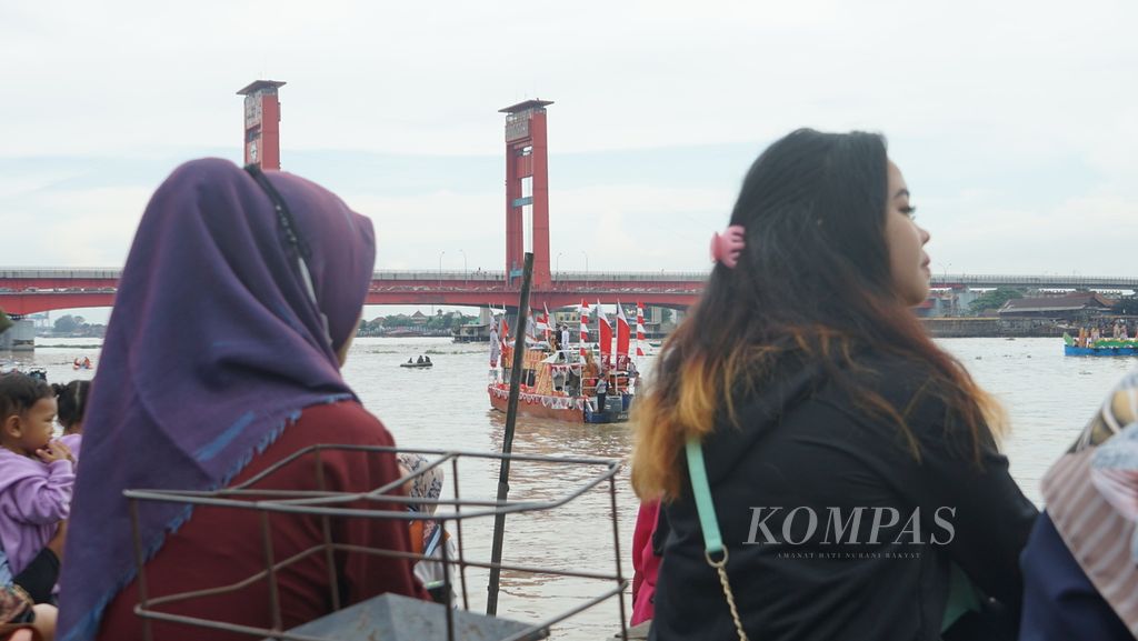 Sejumlah warga Palembang menyaksikan parade perahu hias di pelataran Benteng Kuto Besak Palembang, Sumatera Selatan, Sabtu (20/8/2022). Parade ini merupakan rangkaian dari perayaan Hari Ulang Tahun Ke-77 Republik Indonesia. Acara tahunan ini sempat ditiadakan dua kali karena pandemi covid-19.