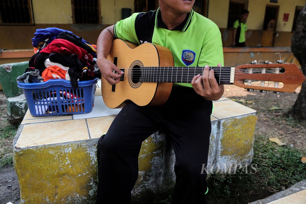 Anak binaan bermain gitar di depan sel tahanan di Lembaga Pembinaan Khusus Anak (LPKA) Kelas I Tangerang, Banten, makan bersama pada Rabu (23/8/2023).