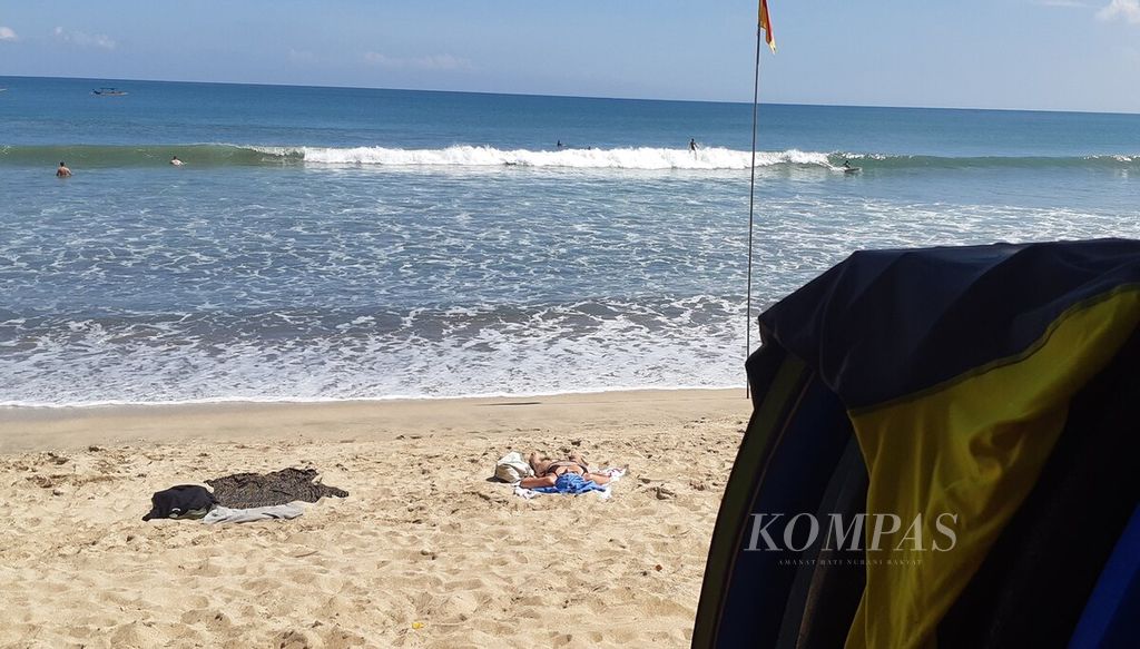 Pantai Kuta menjadi lokasi berselancar ombak. Suasana di Pantai Kuta, Badung, Senin (6/6/2022).