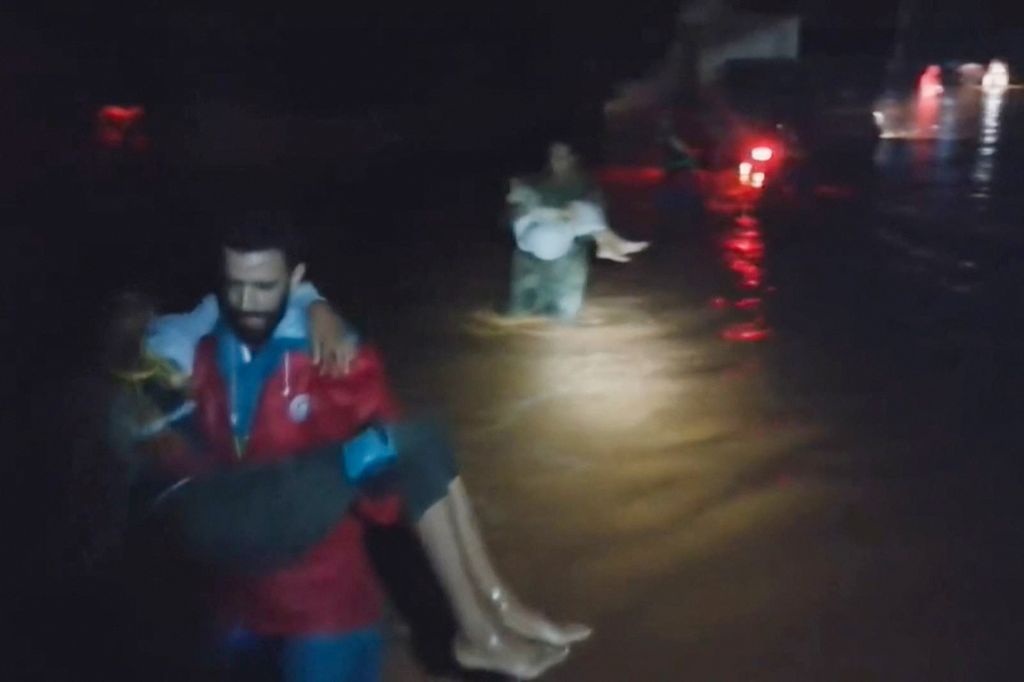 Cuplikan video yang dirilis oleh Bulan Sabit Merah Libya pada 11 September 2023, menunjukkan anggota tim mereka menyelamatkan orang-orang dari banjir di lokasi yang tidak ditentukan di Libya timur. 