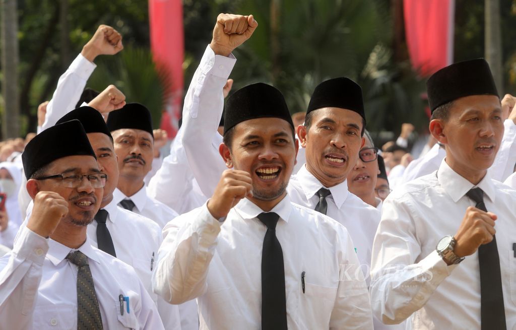 Guru honorer mengepalkan tangan seusai dilantik dalam upacara di halaman Balai Kota DKI Jakarta, Gambir, Jakarta Pusat, Jumat (28/7/2023). 