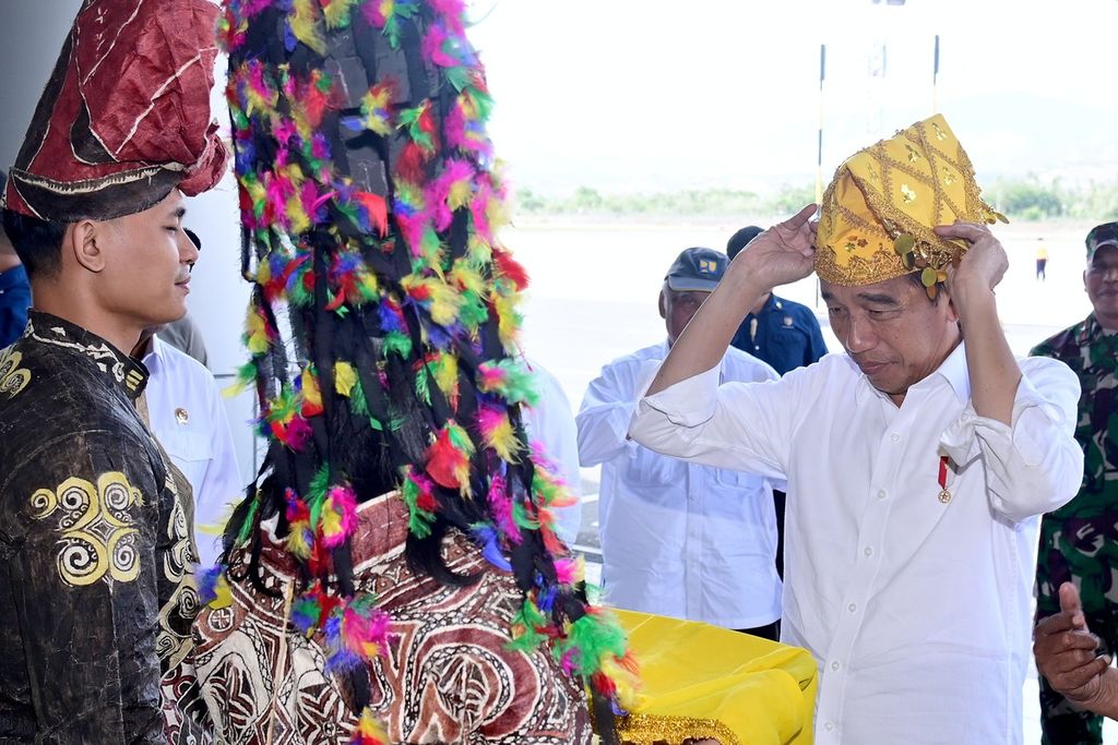 Presiden Joko Widodo mengenakan penutup kepala siga saat tiba di Kota Palu, Sulawesi Tengah, Selasa (26/3/2024). Siga menjadi bentuk penghargaan masyarakat Sulteng atas kedatangan presiden.