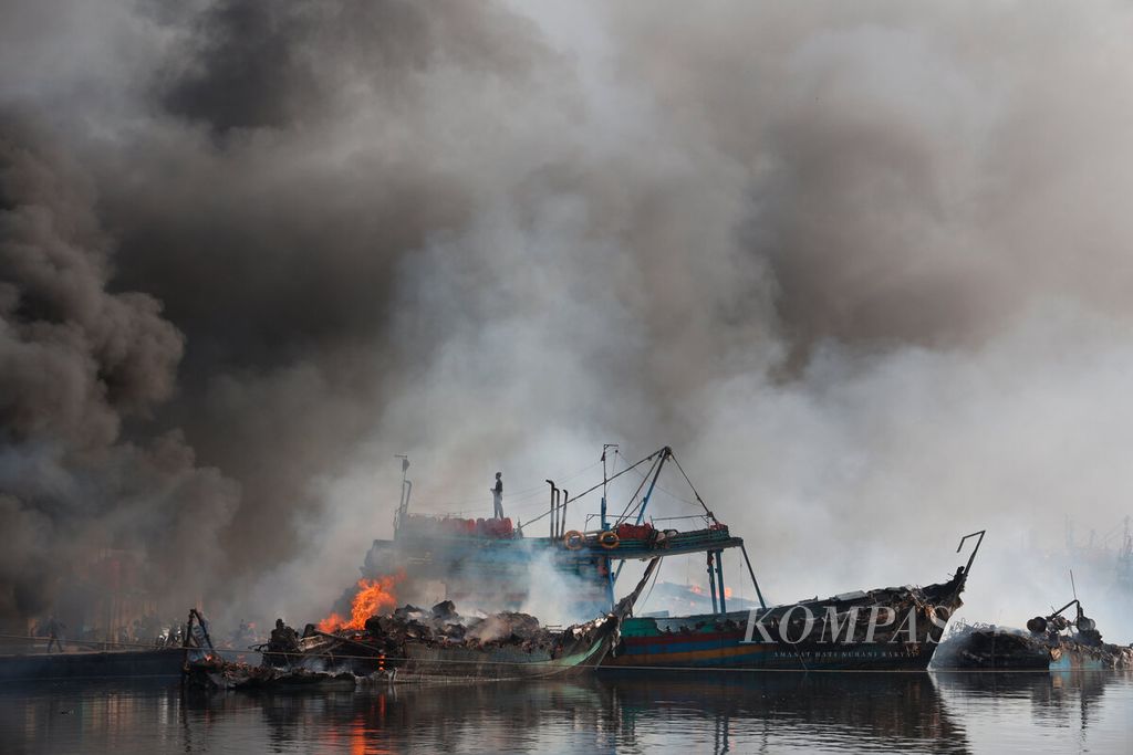  Anak buah kapal berada di atas atap ruang kemudi kapal yang sempat terbakar bersama puluhan kapal lainnya di Pelabuhan Jongor, Kota Tegal, Jawa Tengah, Selasa (15/8/2023). 