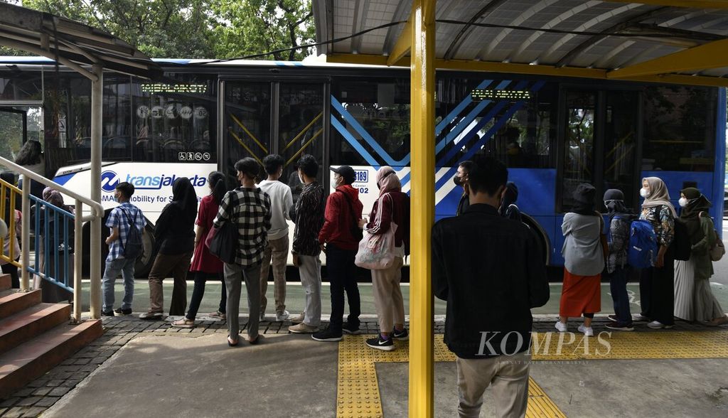 Warga antre naik bus Transjakarta di Jalan Medan Merdeka Selatan, Jakarta Pusat, Sabtu (8/1/2022). Warga cenderung tetap beraktivitas di luar rumah saat akhir pekan meski saat ini dibayangi lonjakan kasus baru Covid-19, terutama varian Omicron. 