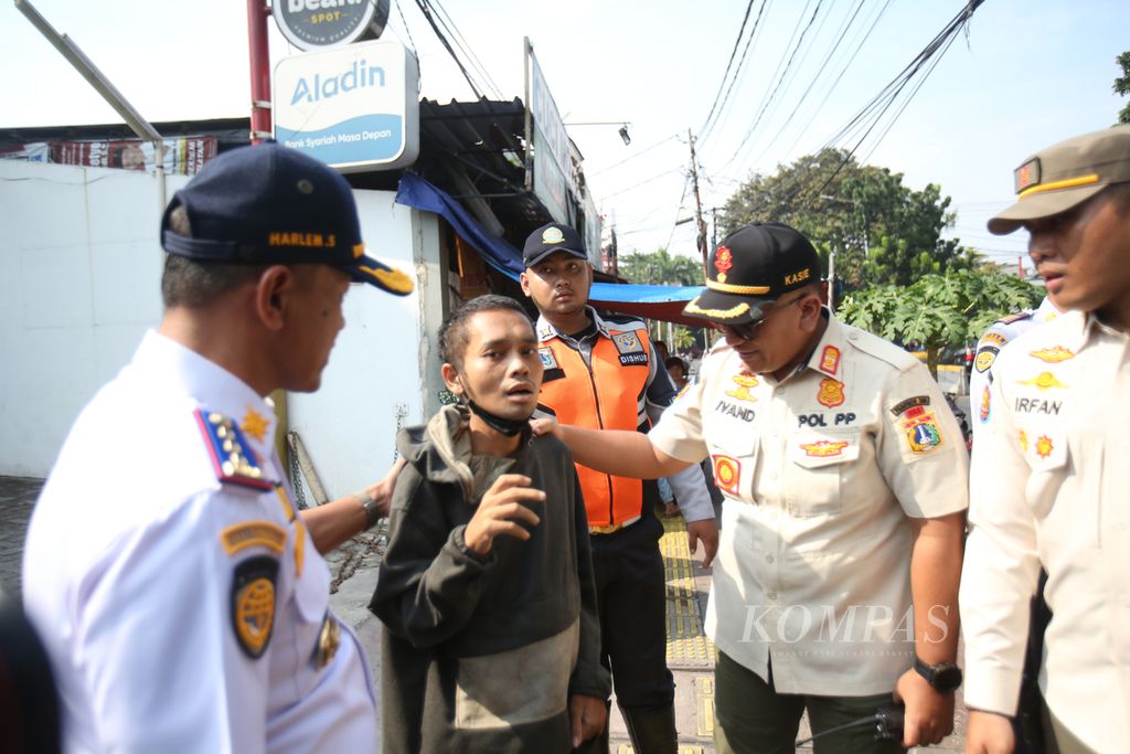 Petugas dari Dinas Perhubungan DKI Jakarta, Satpol PP, TNI, dan Kepolisian menggelar operasi penertiban terhadap juru parkir minimarket di kawasan Kemayoran, Jakarta, Rabu (15/2/2024). 