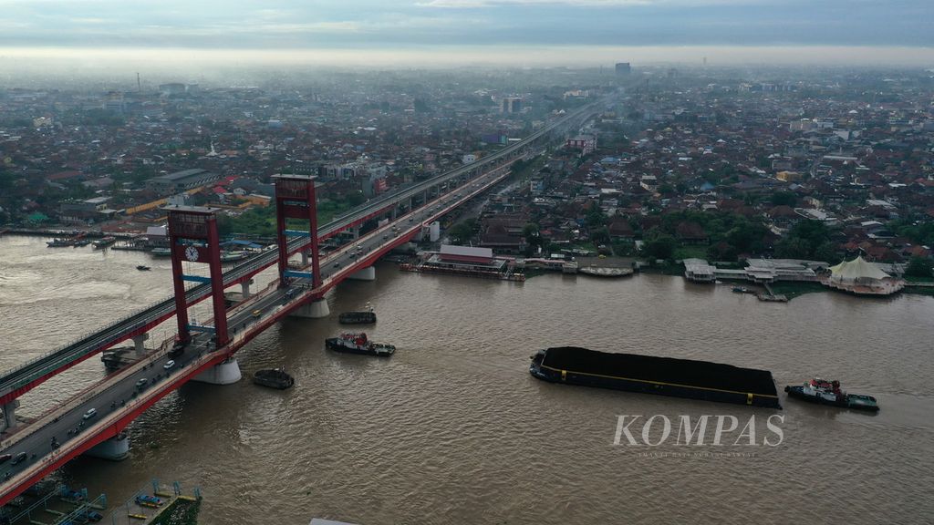 Tongkang bermuatan batubara melintasi Jembatan Ampera di Kota Palembang, Sumatera Selatan, Sabtu (25/3/2023). Batubara tersebut dikumpulkan dari sejumlah tempat penampungan di Kabupaten Muara Enim dan Kabupaten Lahat, selanjutnya diangkut tongkang batubara melintasi Sungai Musi.