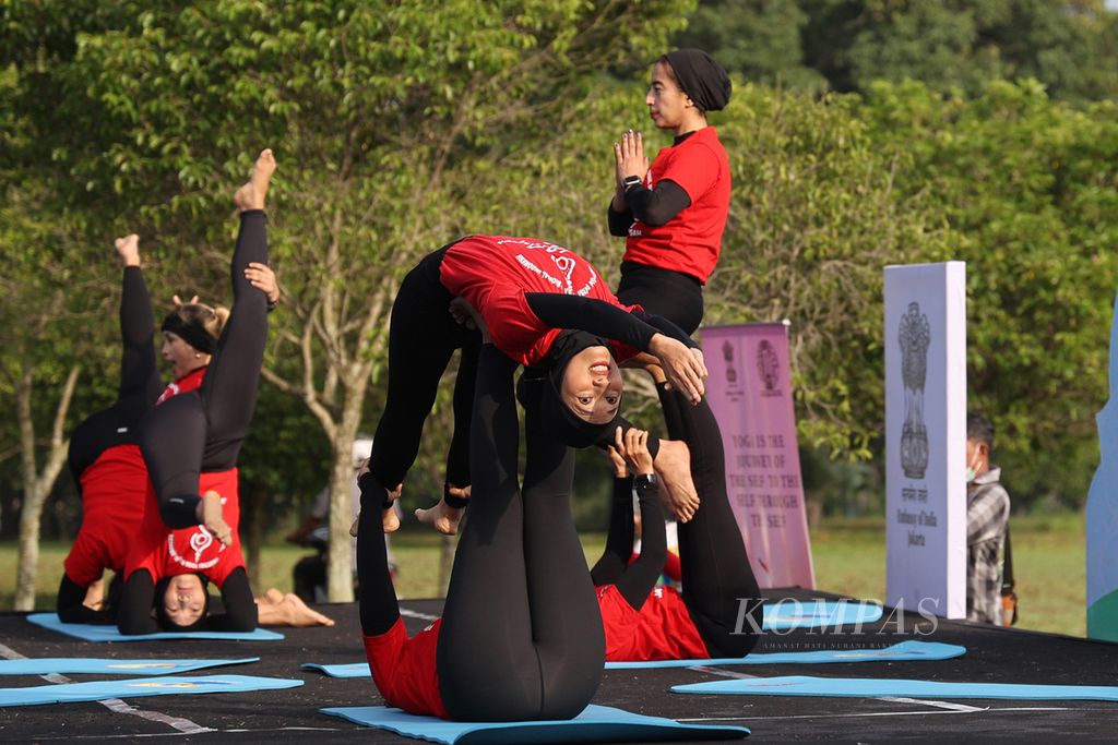 Anggota Perkumpulan Praktisi Yoga Nasional Indonesia (PPYNI) Jawa Tengah menunjukkan gerakan yoga saat mengikuti peringatan Hari Yoga Internasional di kompleks Taman Wisata Candi Prambanan, Sleman, DI Yogyakarta, Selasa (21/6/2022). 