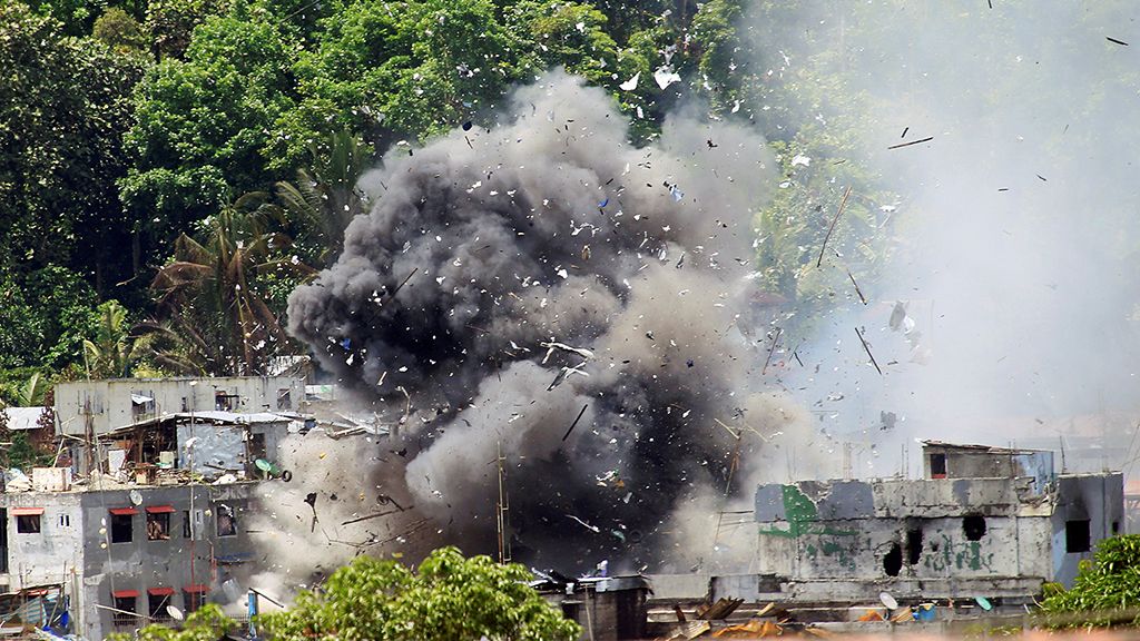 Serpihan material tersebar ke berbagai arah dan asap membubung, Selasa (20/6), setelah pesawat OV-10 Bronco milik Filipina menjatuhkan bom di sebuah kawasan di  Marawi, Pulau Mindanao, Filipina selatan. Militer Filipina menyatakan meningkatkan tekanan atas kelompok ekstrem Maute di Marawi.   