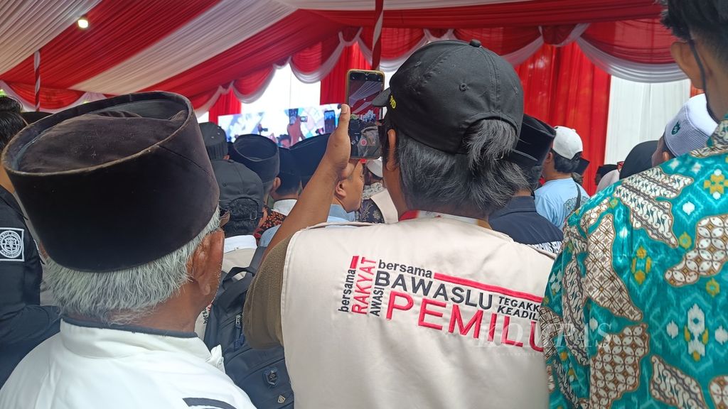 Petugas dari Badan Pengawas Pemilu (Bawaslu) mengawasi jalannya acara penyerahan bantuan sumur bor dan pipanisasi di Pondok Pesantren Al Anwar, Kabupaten Bangkalan, Jawa Timur, Selasa (23/1/2024).