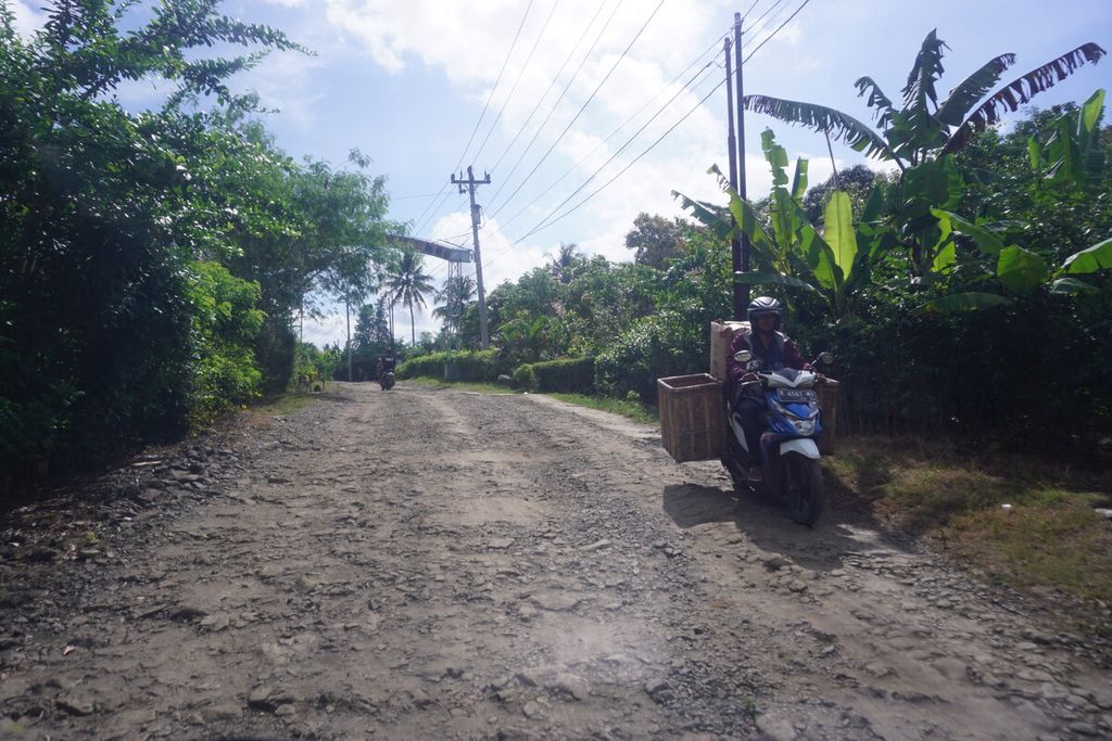 Pengendara melintasi jalan yang rusak parah antara Kecamatan Jeruklegi dan Kecamatan Kawunganten, Kabupaten Cilacap, Jawa Tengah, Sabtu (15/4/2023).