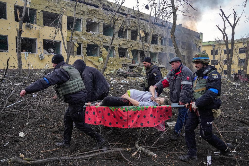 Warga membawa Iryna Kalinina (32), seorang perempuan yang tengah hamil dan terluka akibat serangan udara Rusia di kota Mauripol, Ukraina. Sempat dirawat, Iryna dan bayinya akhirnya meninggal. Foto karya Evgeniy Maloletka ini menjadi pemenang Photo of the Year dalam ajang World Press Photo 2023.