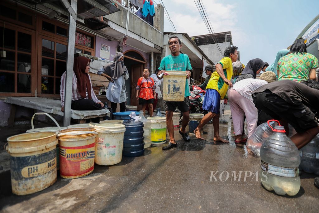 Warga mengangkut ember berisi air bersih dari tangki mobil PAM Jaya di RW 011, Kecamatan Kalideres, Jakarta Barat, Kamis (14/9/2023). 
