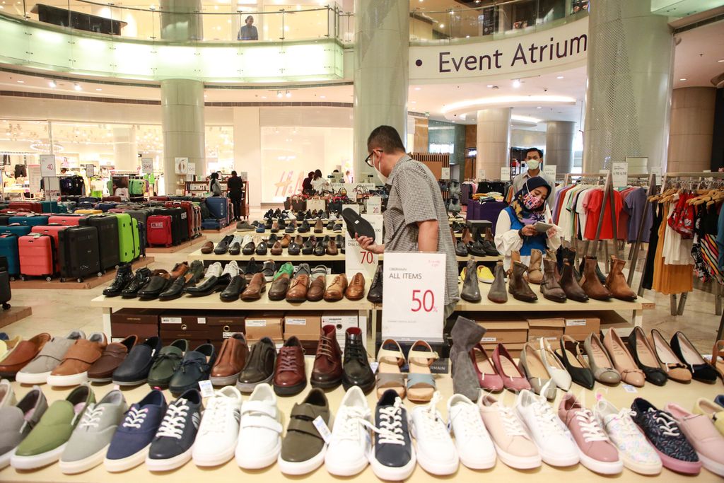 Pengunjung melihat produk alas kaki yang ditawarkan dengan potongan harga di pusat perbelanjaan Lotte Shopping Avenue di Jakarta, Kamis (11/8/2022).  