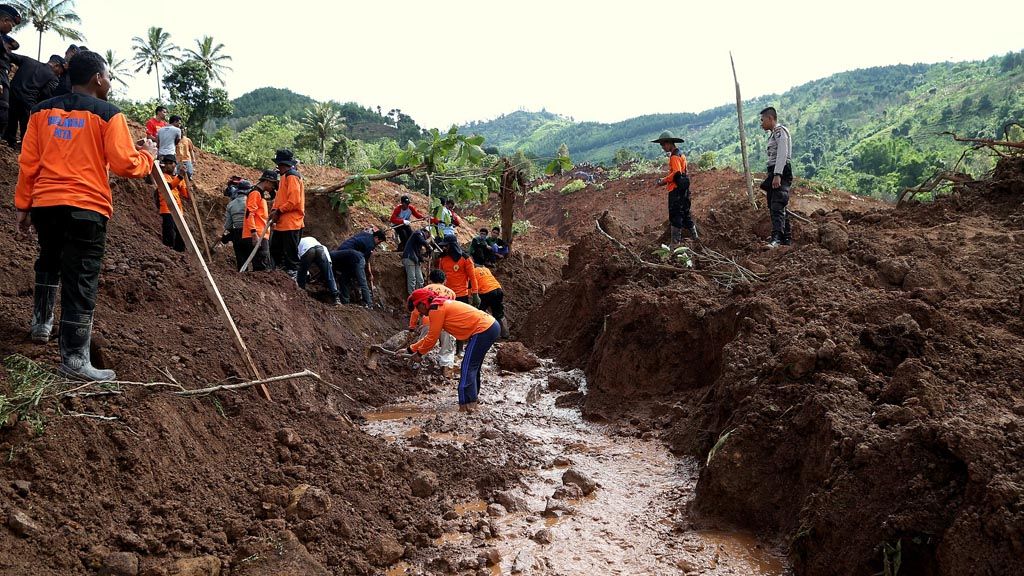 Relawan gabungan dari berbagai unsur memulai pencarian korban  tanah longsor di  Dusun Tangkil, Desa Banaran, Kecamatan Pulung, Ponorogo, Jawa Timur, Minggu (2/4). Evakuasi pencarian korban longsor mulai dilakukan pada hari itu dengan mengerahkan eskavator.