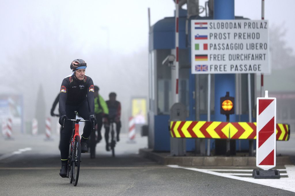 Para pesepeda melintasi pintu perbatasan Rupa antara Kroasia dan Slovenia untuk pertama kalinya tanpa pemeriksaan imigrasi di Kroasia, Minggu (1/1/2023). 