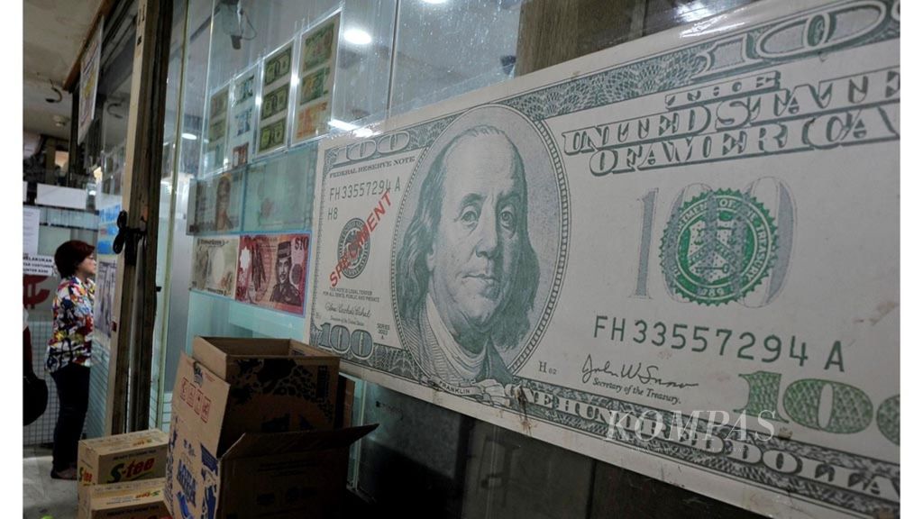 Gambar mata uang dollar AS terpasang di salah satu tempat penukaran uang di Jakarta, Jumat (31/8/2018).