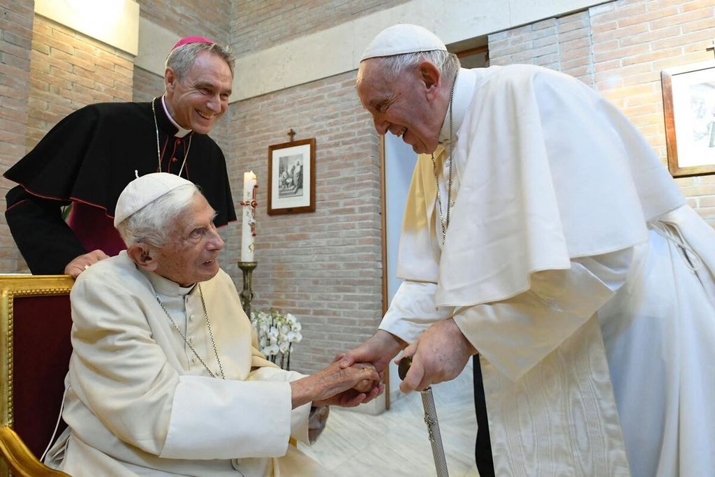 Dalam foto arsip yang diambil dan dibagikan pada 27 Agustus 2022 oleh The Vatican Media, Paus Fransiskus (kanan) memberi hormat kepada Paus Emeritus Benediktus XVI (kiri), sementara ajudan Benediktus XVI, Georg Gaenswein, terlihat saat mereka bersiap bertemu dengan para kardinal baru setelah konsistori untuk mengangkat 20 kardinal baru di Vatikan.