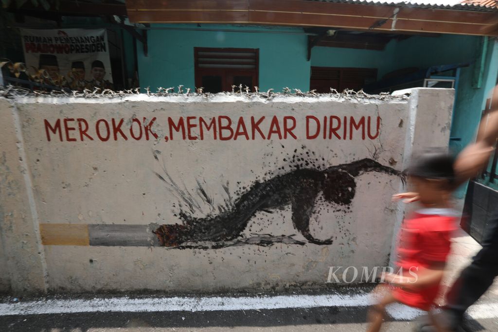Mural bertema kawasan bebas asap rokok menghiasi permukiman warga di lingkungan RW 006 Kelurahan Kayu Manis, Matraman, Jakarta Timur, Selasa (14/11/2023).