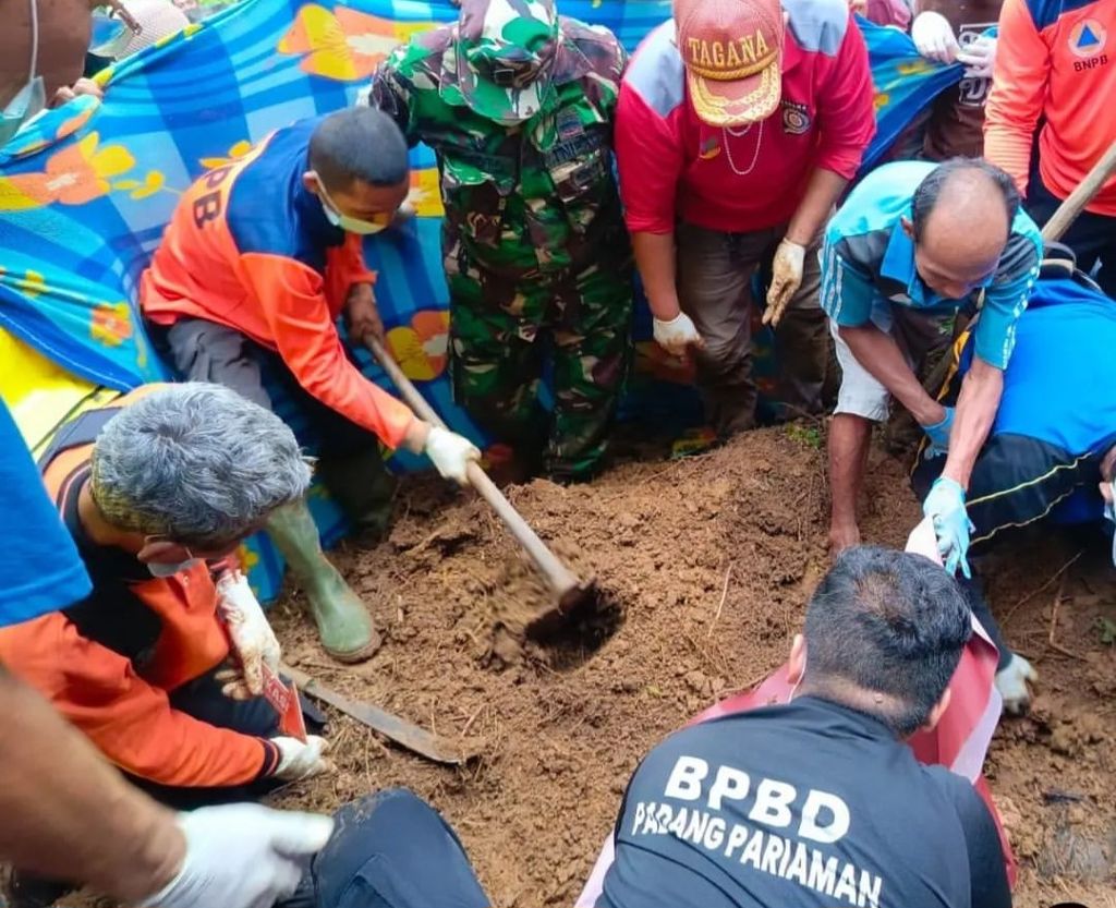 Petugas melakukan evakuasi terhadap jenazah Nia Kurnia Sari (18), pedagang gorengan, yang ditemukan terkubur areal hutan di Korong Pasa Surau, Nagari Guguak, Kecamatan 2 x 11 Kayu Tanam, Kabupaten Padang Pariaman, Sumatera Barat, Minggu (8/9/2024). 