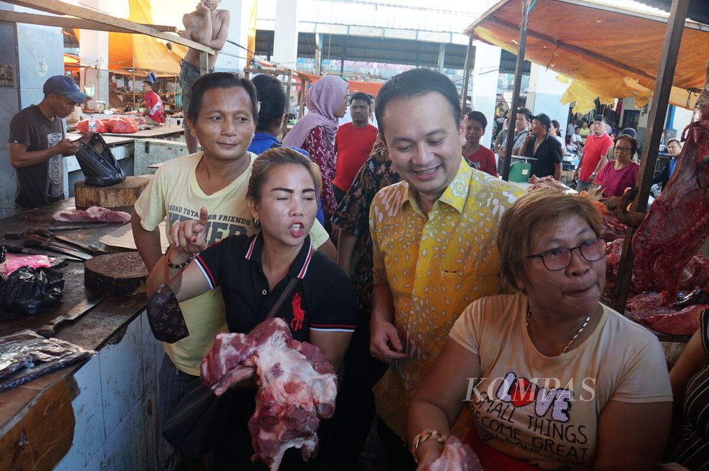 Wakil Menteri Perdagangan Jerry Sambuaga bercengkerama dengan para pedagang daging babi, Jumat (13/12/2019), dalam kunjungannya ke Pasar Pinasungkulan, Manado, Sulawesi Utara.