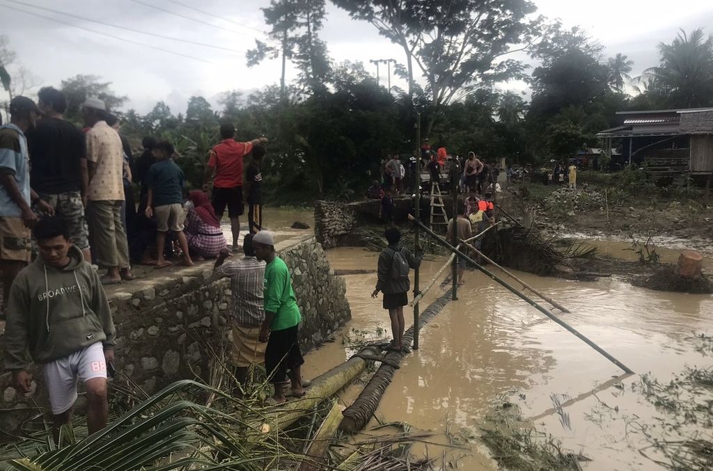 Tim SAR gabungan meniti jembatan darurat untuk menjangkau desa-desa yang terdampak banjir bandang di Kecamatan Toribulu, Parigi Moutong, Sulteng, Minggu (23/6/2024).