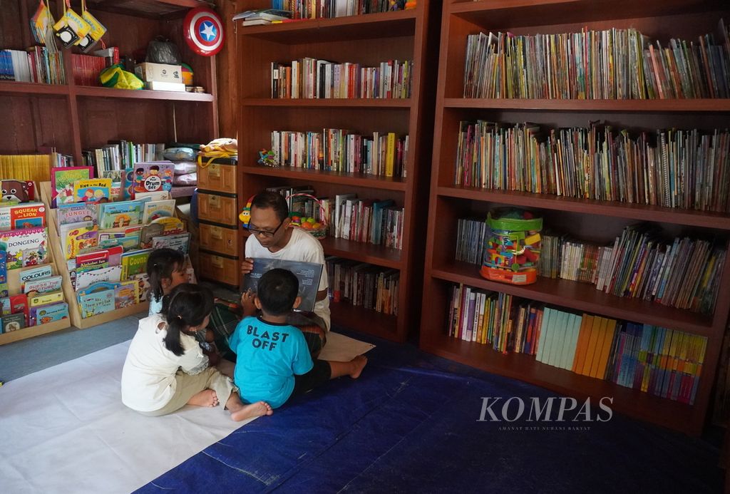 Yulianto (31), pegiat listerasi, membacakan buku cerita kepada anak-anak yang berkunjung ke Rumah Baca Bintang di Desa Sumberjosari, Kecamatan Karangrayung, Kabupaten Grobogan, Jawa Tengah, Sabtu (14/5/2022). Rumah baca itu merupakan satu dari empat rumah baca yang ia kelola di Grobogan.