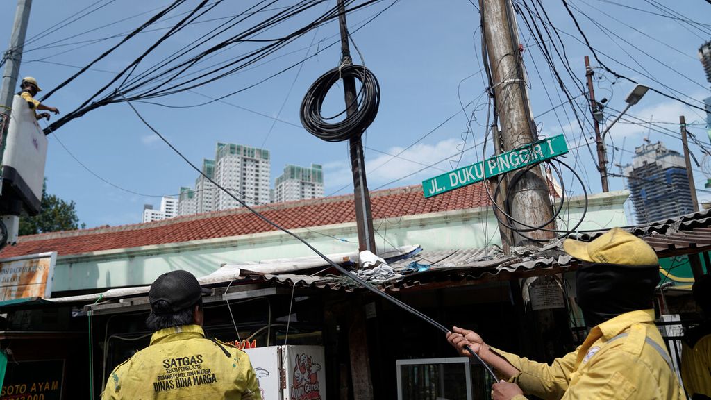 Satgas Pemeliharaan Simpang Jalan Tak Sebidang Dinas Bina Marga DKI Jakarta dalam penataan kabel udara di Jalan Mas Mansyur, Tanah Abang, Jakarta Pusat, Sabtu (21/11/2020). 