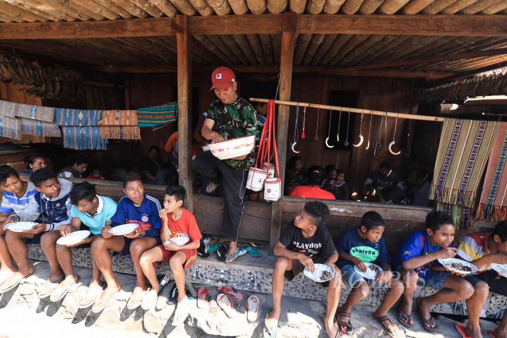 Warga kampung adat Bena menikmati hidangan dari rangkaian upacara pasang atap rumah adat atau dalam bahasa setempat disebut Wae Sao di Desa Tiworiwu, Kecamatan Jerebu'u, Kabupaten Ngada, Nusa Tenggara Timur, Senin (5/8/2019). 