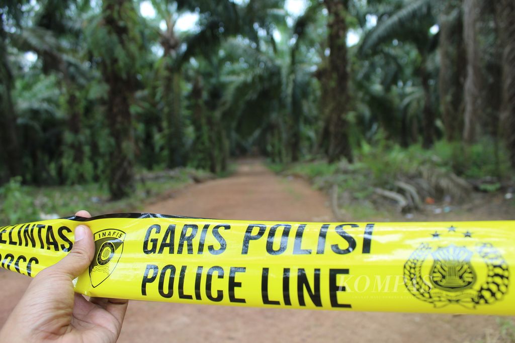 Polisi menutup akses ke TKP kejadian penembakan warga Desa Bangkal di Kabupaten Seruyan, Kalteng, Rabu (11/10/2023). Akses ditutup dengan garis kuning polisi.