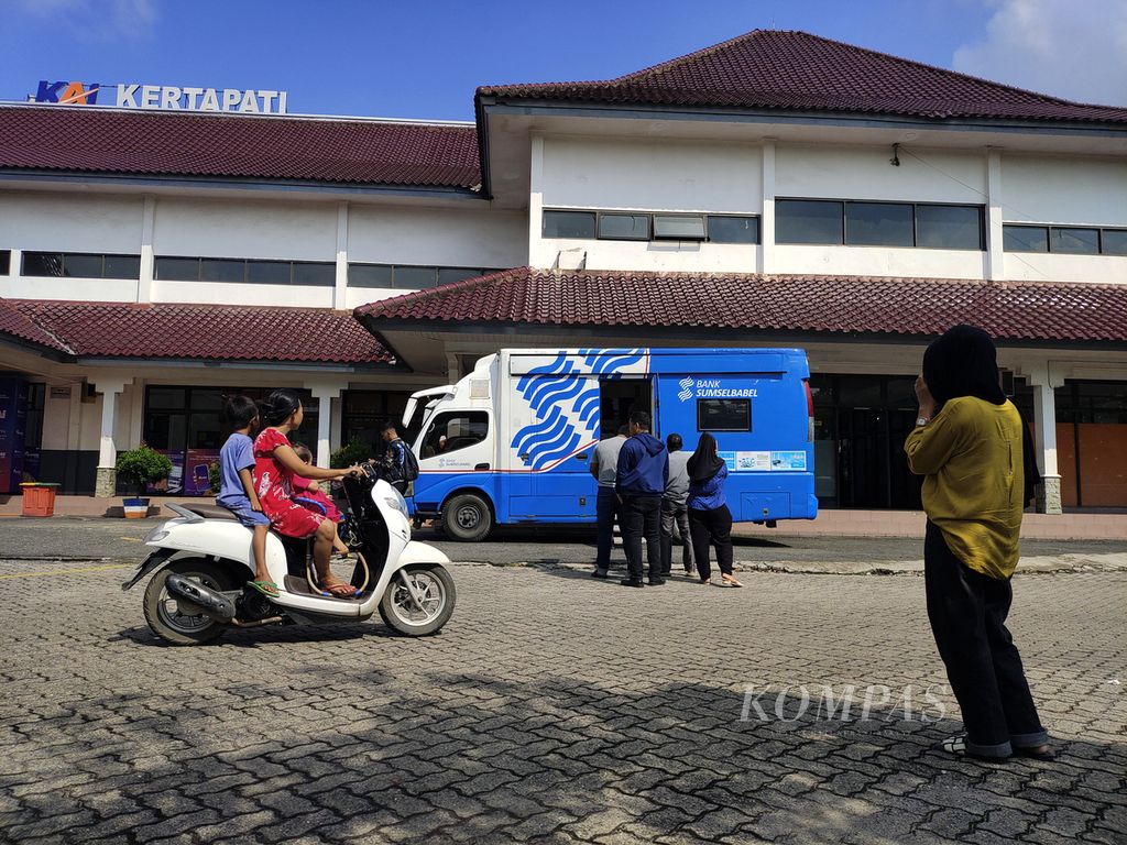 Warga menghampiri mobil layanan pendaftaran program Gerakan Mudik Gratis Serentak Se-Sumatera Selatan untuk moda transportasi kereta api di halaman Stasiun Kertapati, Palembang, Sumatera Selatan, Jumat (22/3/2024). 
