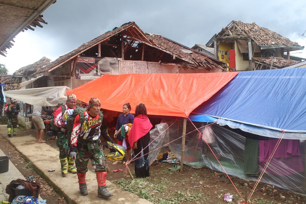 Sejumlah personel tim Kopassus Trail Adventure melintasi pengungsian di Desa Sarampad, Kecamatan Cugenang, Cianjur, Jawa Barat, Sabtu (26/11/2022).