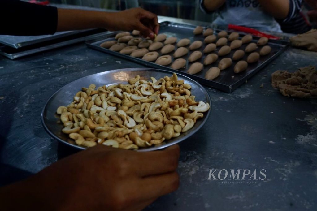 Karyawan toko oleh-oleh Bravo mengolah mete untuk ditaburkan di kue khas daerah, di Kendari, Sulawesi Tenggara, Minggu (23/7/2023). Mete dan berbagai bentuk olahannya menjadi pilihan utama masyarakat saat berkunjung ke wilayah ini.