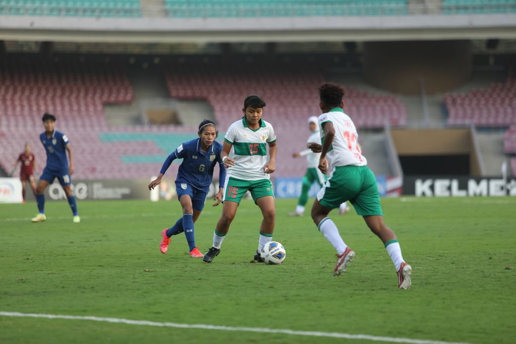 Pemain timnas putri Indonesia, Helsya Maeisyaroh, mengontrol bola dengan dibayang-bayangi pemain Thailand di babak penyisihan Grup B Piala Asia Putri 2022 di Stadion DY Patil, Mumbai, India, Senin (24/1/2022) malam