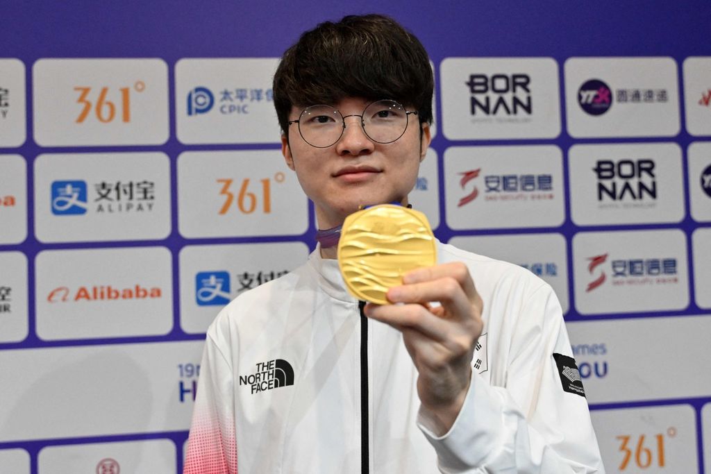 Peraih medali emas dari cabang e-sport Asian Games, asal Korea Selatan, Lee Sang-hyeok alias Faker, menunjukkan medalinya di nomor League of Legends. Dia berhak mendapatkan pengecualian wajib militer.