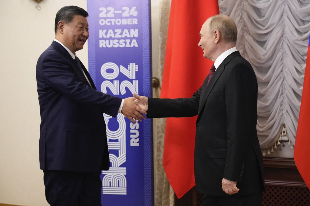 Presiden Rusia Vladimir Putin (kanan) berjabat tangan dengan Presiden China Xi Jinping saat bertemu di sela-sela KTT BRICS di Kazan, Rusia, Selasa (22/10/2024). 